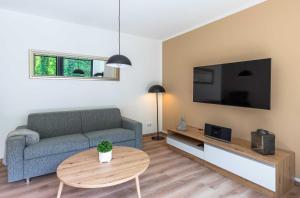 a living room with a couch and a table at Apartment Frau Hummel - Urlaub am Krakower See in Krakow am See