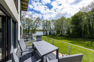 a balcony with a table and chairs and a view of a lake at Apartment Frau Hummel - Urlaub am Krakower See in Krakow am See +12 photos