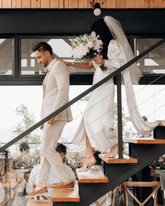 a bride and groom are walking down a staircase at Casas na montanha - Villa Montegrappa in Caxias do Sul +110 photos