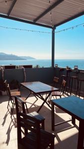 a patio with tables and chairs and a view of the ocean at An House Son Tra in Danang