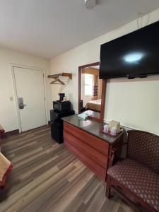 a living room with a couch and a desk with a microwave at Snowbird Motel in Bristol