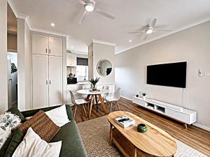 a living room with a couch and a tv at Coastal Bliss in Lemon Tree Passage