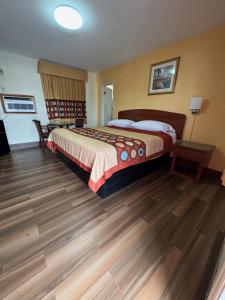 a bedroom with a large bed and a wooden floor at Snowbird Motel in Bristol