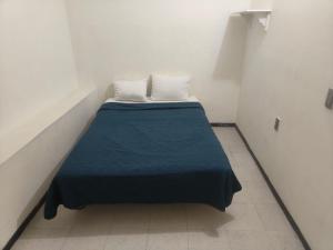 a small room with a bed with a blue blanket at Hostal Ciudad de México - Habitaciones privadas con Wi-Fi en el centro histórico in Mexico City +49 photos
