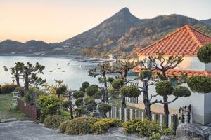 a view of a lake with a house and trees at namhe acro pension in Namhae