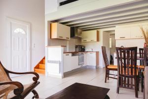 a kitchen with white appliances and a table and chairs at Domaine de Pitrot in Lacanau