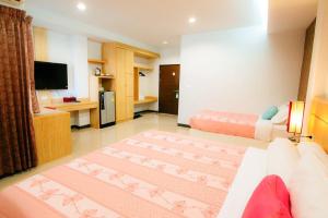 a large living room with a couch and a television at The Rama Hotel in Chiang Rai