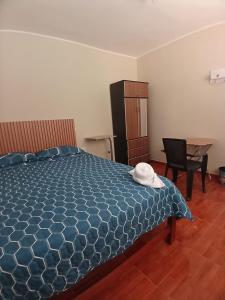 a bedroom with a bed and a chair and a desk at Alójate Huánuco in Huánuco