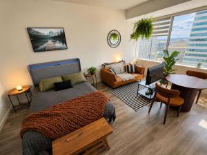 a bedroom with a bed and a living room at Boho Studio Downtown Rogers Views Heated Parking in Edmonton