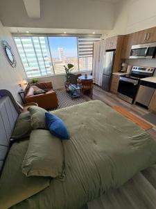 a large bed in a room with a kitchen at Boho Studio Downtown Rogers Views Heated Parking in Edmonton