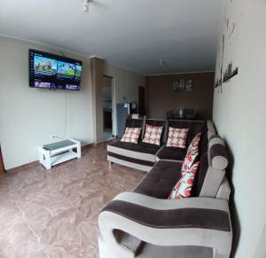 a living room with two couches and a tv at Alójate Huánuco in Huánuco