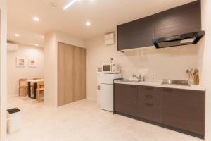 a kitchen with a white refrigerator and a sink at coconehouse namba family type in Osaka +17 photos