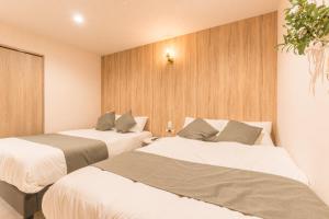 two beds in a hotel room with at coconehouse namba family type in Osaka