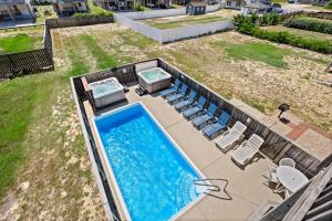 an overhead view of a swimming pool with chairs at 6151 - Once Upon a Tide in Nags Head