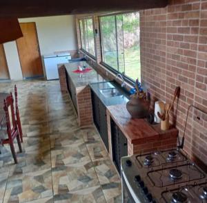 a kitchen with a stove and a brick wall at Sítio Santo Expedito in Salesópolis
