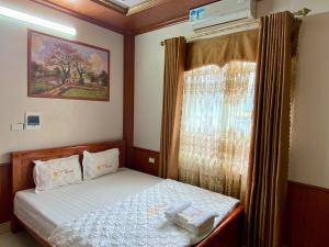 a small bedroom with a bed and a window at Khách sạn Tam Sơn in Ha Giang