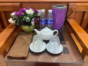 a tray with a tea pot and two bottles of water and flowers at Khách sạn Tam Sơn in Ha Giang