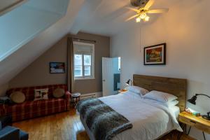 a bedroom with a bed and a couch at Aux petits oiseaux in Baie-Saint-Paul