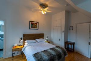 a bedroom with a bed and a ceiling fan at Aux petits oiseaux in Baie-Saint-Paul +30 photos