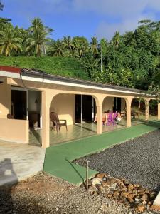 a house with a green roof with a yard at Sarahlodge in Tahaa