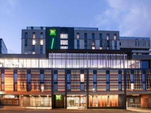 a building with a green sign on top of it at Ibis Styles Hobart in Hobart