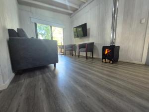 a living room with a couch and a stove at cabañasmanantialpanguipulli in Panguipulli
