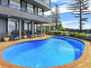 a large blue swimming pool in front of a building at ibis Styles Port Macquarie in Port Macquarie