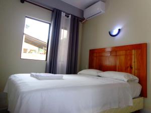 a bedroom with a large white bed with a window at Pampa & Selva in Rurrenabaque +10 photos