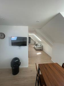 a living room with a table and a tv on a wall at herseaux in Mouscron
