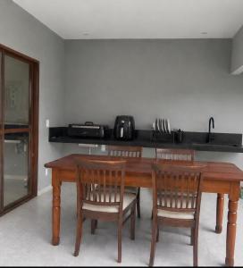 a kitchen with a wooden table and four chairs at Casa Cerejeiras - Condomínio Privado in Bananeiras