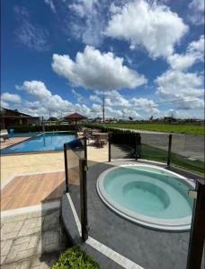 a large pool with a hot tub next to a patio at Casa Cerejeiras - Condomínio Privado in Bananeiras