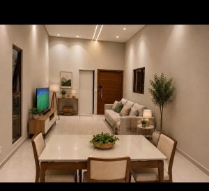 a living room with a table and a couch at Casa Cerejeiras - Condomínio Privado in Bananeiras