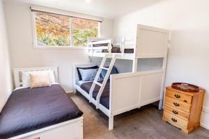 a bedroom with bunk beds and a window at Ovens River Retreat in Harrietville