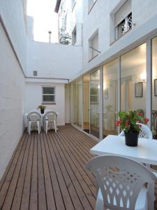 una terraza al aire libre con mesa blanca y sillas en Apartament El Miracle, en Cardona