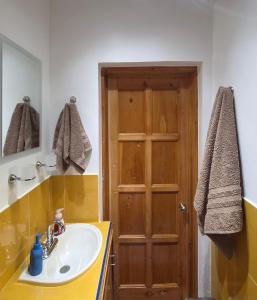 a bathroom with a sink and a wooden door at Loft Juárez in Amecameca de Juárez