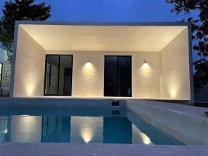 a house with a swimming pool in front of it at Casa Nahox in Hunucmá
