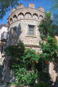 an old stone building with flowers in front of it at Lesvos Tower House Komninos in Sígrion