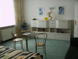 Gaestehaus Rehbein في Calbe: غرفة نوم مع مكتب وطاولة وكراسي