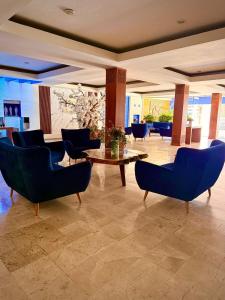 a lobby with blue chairs and a table in a room at Hotel Tlayolan in Ciudad Guzmán