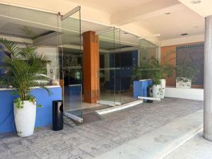 a glass facade of a building with potted plants at Hotel Tlayolan in Ciudad Guzmán