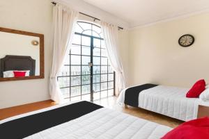 a bedroom with two beds and a large window at Hotel San Jose Centro Historico in San Luis Potosí