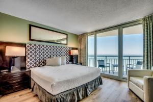 a bedroom with a large bed and a balcony at Oceanfront Paradise Sleeps 10 w Stunning Sunrises in Myrtle Beach