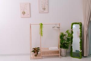 a mirror in a white room with plants at HeavenVilla in Can Tho +26 photos