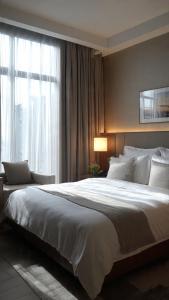 a bedroom with a large white bed with a window at Komodo Island in Ruda