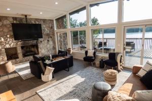 a living room with a fireplace and a tv at Modernist Lakefront Sojourn in Monticello