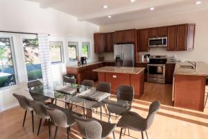 a kitchen with a glass dining table and chairs at Modernist Lakefront Sojourn in Monticello