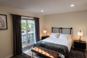 a bedroom with a bed and a large window at Modernist Lakefront Sojourn in Monticello