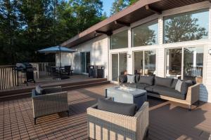 a patio with couches and chairs and a table at Modernist Lakefront Sojourn in Monticello