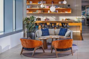 a living room with a couch and a table and chairs at art'otel cologne in Cologne