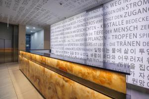 a wall with writing on it in a lobby at art'otel cologne in Cologne